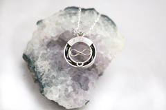Rond zilveren hangertje met infinity teken, hartje en drie edelstenen